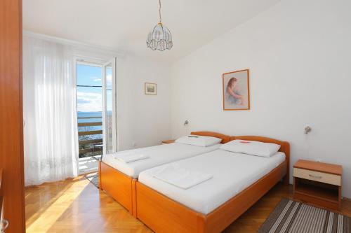 sypialnia z łóżkiem i dużym oknem w obiekcie Apartments by the sea Seget Vranjica, Trogir - 6094 w mieście Seget Vranjica