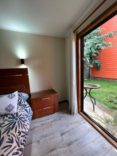 a bedroom with a bed and a window with a table at Hotel Boutique Family Suites in Panguipulli