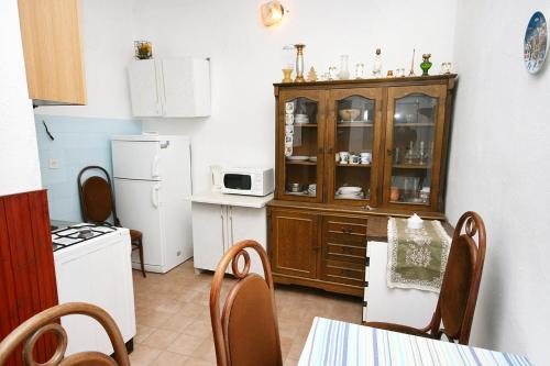 une cuisine avec une armoire et une table avec des chaises dans l'établissement Apartments by the sea Drasnice, Makarska - 6051, à Drašnice