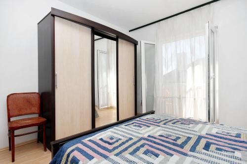 a bedroom with a bed and a chair and a window at Apartment Drasnice 6051b in Drasnice