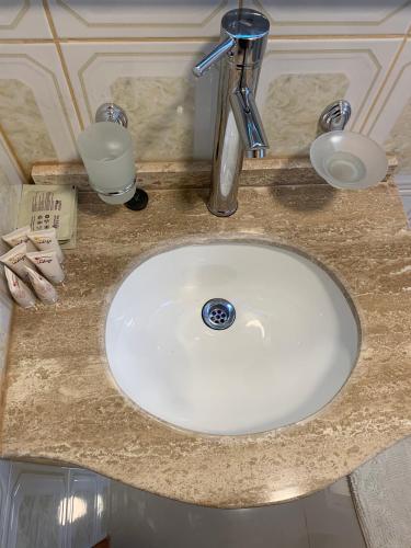 a bathroom counter with a white sink with a faucet at Hotel Boutique Family Suites in Panguipulli