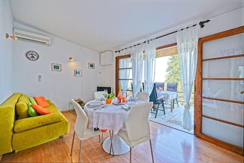 a living room with a table and a yellow couch at Holiday house with a parking space Postira, Brac - 6052 in Postira
