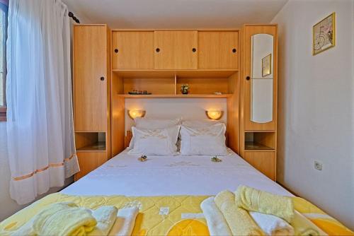 a small bedroom with a bed with wooden cabinets at Holiday house with a parking space Postira, Brac - 6052 in Postira