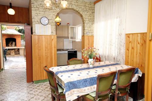 cocina con mesa con sillas y cocina con chimenea en Apartments by the sea Arbanija, Ciovo - 6062, en Trogir