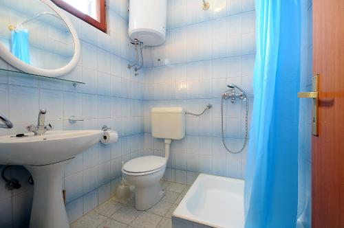 a bathroom with a toilet and a sink and a shower at Seaside apartments with a swimming pool Nin, Zadar - 6153 in Nin