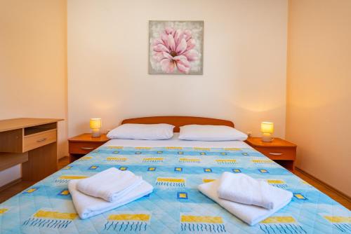 a bedroom with a large bed with towels on it at Seaside apartments with a swimming pool Posedarje, Novigrad - 6162 in Posedarje