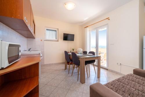 a kitchen and dining room with a table and chairs at Seaside apartments with a swimming pool Posedarje, Novigrad - 6162 in Posedarje