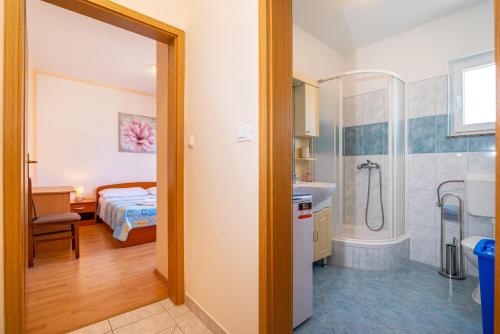 een badkamer met een douche en een slaapkamer bij Seaside apartments with a swimming pool Posedarje, Novigrad - 6162 in Posedarje