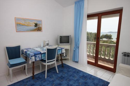 a room with a table and chairs and a balcony at Apartments and rooms by the sea Vodice - 6182 in Vodice