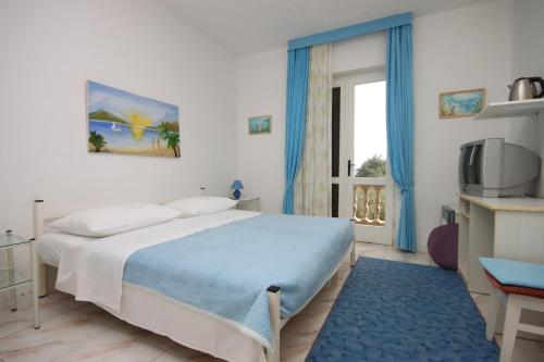 a bedroom with a bed and a tv and a window at Apartments and rooms by the sea Vodice - 6182 in Vodice