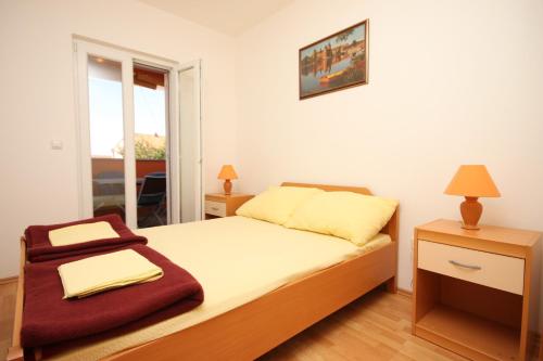 a small bedroom with a bed and a window at Apartments with a parking space Vodice - 6183 in Vodice
