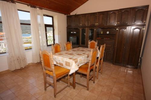 a dining room with a table and wooden cabinets at Apartments with a parking space Grebastica, Sibenik - 6103 in Grebaštica