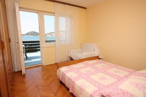 a bedroom with a bed and a large window at Apartments by the sea Tisno, Murter - 6106 in Tisno