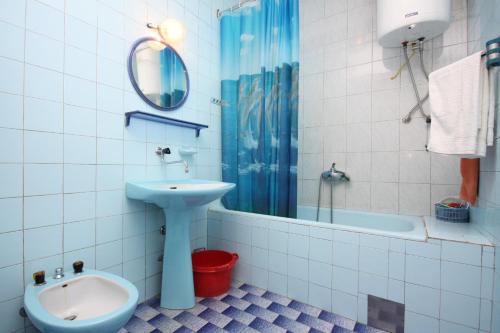 La salle de bains est pourvue d'un lavabo, de toilettes et d'une baignoire. dans l'établissement Apartments by the sea Tisno, Murter - 6106, à Tisno