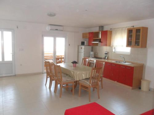 eine Küche mit einem Tisch und Stühlen im Zimmer in der Unterkunft Apartments with a parking space Ljubac, Zadar - 6141 in Ražanac