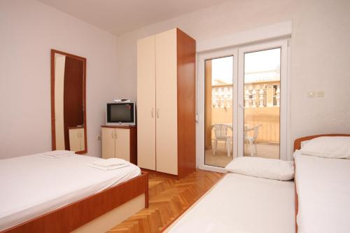 ein Hotelzimmer mit 2 Betten und einem TV in der Unterkunft Apartments with a parking space Sveti Petar, Biograd - 6169 in Sveti Petar