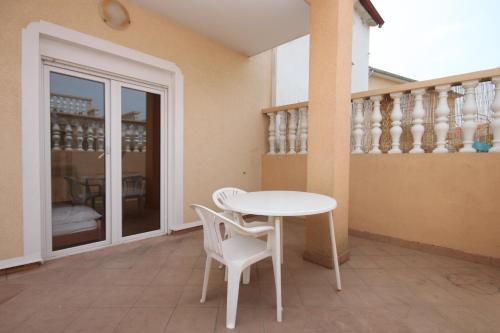 einen weißen Tisch und zwei weiße Stühle auf einer Terrasse in der Unterkunft Apartments with a parking space Sveti Petar, Biograd - 6169 in Sveti Petar