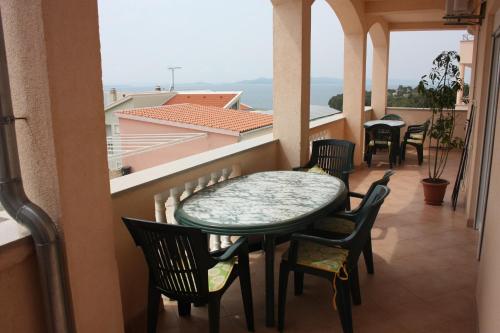 uma varanda com uma mesa e cadeiras e uma vista em Apartments by the sea Drage, Biograd - 6171 em Drage