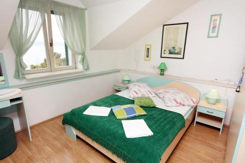 una camera con un letto e una coperta verde di Apartments by the sea Baska Voda, Makarska - 6081 a Baška Voda