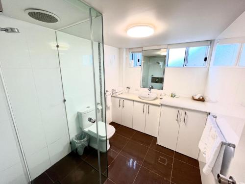 a bathroom with a toilet and a glass shower at H2O Holiday Apartments - Unit 4 in North Haven