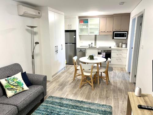 a living room with a couch and a table in a kitchen at H2O Holiday Apartments - Unit 4 in North Haven