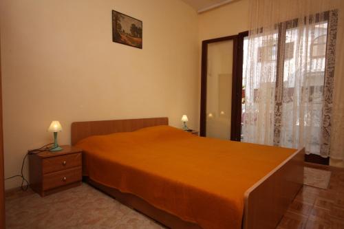 - une chambre avec un grand lit orange et une fenêtre dans l'établissement Apartment Vrsi - Mulo 6155b, à Vrsi