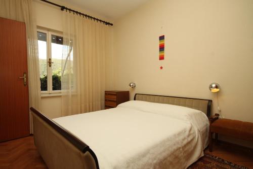拉巴克的住宿－Apartments with WiFi Rabac, Labin - 7472，卧室配有白色的床和窗户。