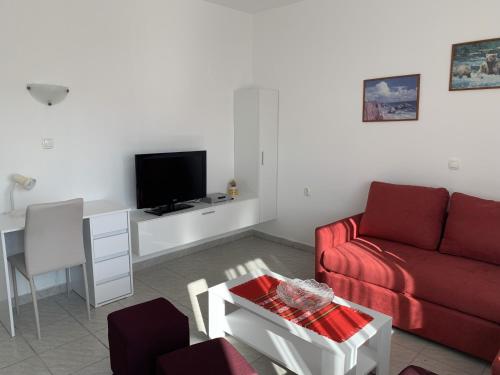 a living room with a red couch and a table at Apartment Rabac 7410e in Rabac