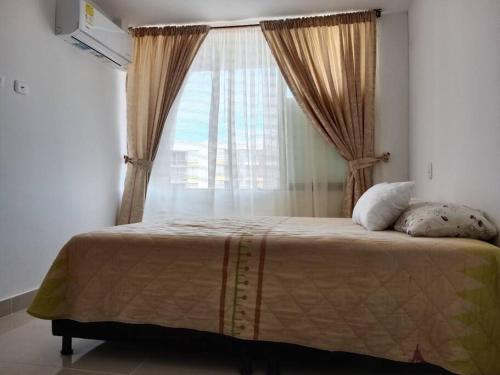 um quarto com uma cama grande e uma janela em Apartamento para tu descanso piso 7 em Ricaurte