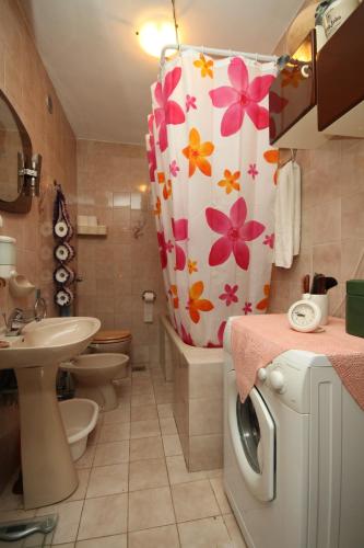 a bathroom with a shower curtain with flowers on it at Apartments with parking space Rabac, Labin - 7465 in Rabac