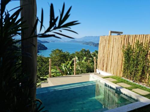 uma piscina com vista para o oceano em Alto da Piraquara Flat em Angra dos Reis