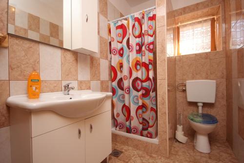 ein Badezimmer mit einem Waschbecken, einem WC und einem Duschvorhang in der Unterkunft Holiday house with a swimming pool Cepic, Central Istria - Sredisnja Istra - 7404 in Pulgarija Čepić