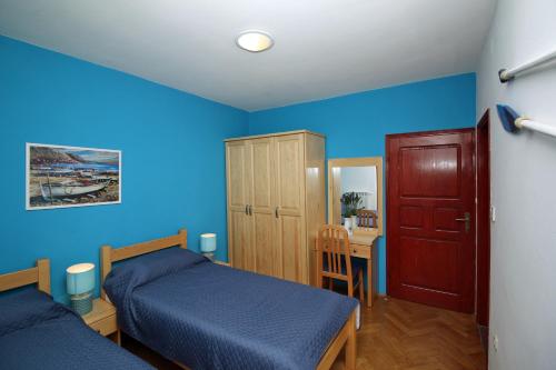 a bedroom with blue walls and two beds and a table at Apartment Rabac 7429a in Rabac