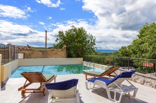 a swimming pool with two chairs and avisorvisor at Holiday house with a swimming pool Kozljak, Central Istria - Sredisnja Istra - 7409 in Plomin