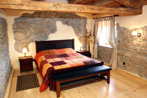 a bedroom with a bed in a stone wall at Holiday house with a swimming pool Kozljak, Central Istria - Sredisnja Istra - 7409 in Plomin