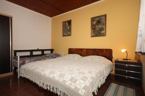 um quarto com uma cama com um edredão branco em Apartments by the sea Seget Vranjica, Trogir - 7509 em Seget Vranjica