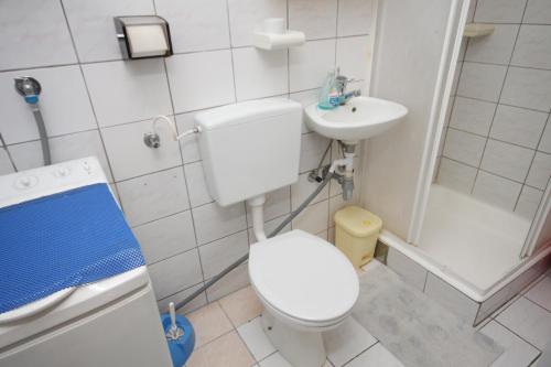 uma pequena casa de banho com WC e lavatório em Apartments by the sea Seget Vranjica, Trogir - 7509 em Seget Vranjica