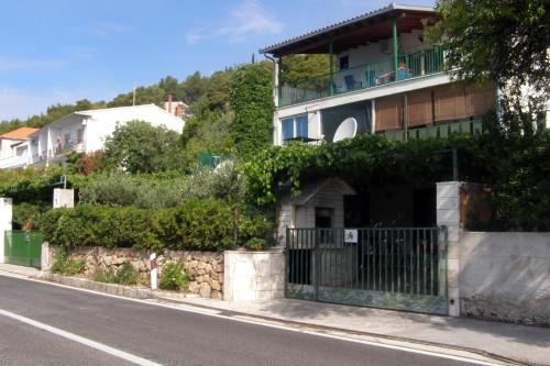 a house with a gate on the side of a street at Apartments by the sea Seget Vranjica, Trogir - 7508 in Seget Vranjica