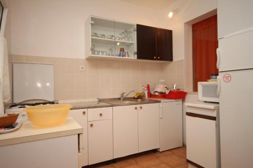 uma cozinha com armários brancos e um lavatório em Apartments by the sea Razanj, Rogoznica - 7517 em Rogoznica