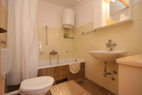 a bathroom with a toilet and a sink and a tub at Apartments with a parking space Valtura, Pula - 7419 in Valtura