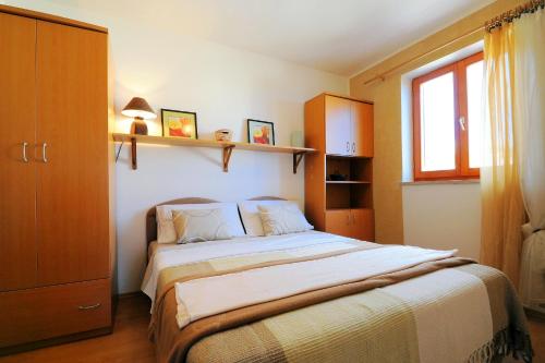 a bedroom with a large bed and a window at Apartments with a parking space Ravni, Labin - 7450 in Ravni