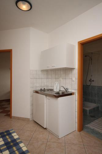 a white kitchen with a sink and a shower at Apartments with parking space Duce, Omis - 7532 in Duće