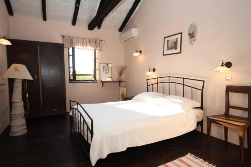 a bedroom with a bed with white sheets and a window at Luxury villa with a swimming pool Skrapi, Central Istria - Sredisnja Istra - 7524 in Brajkovići