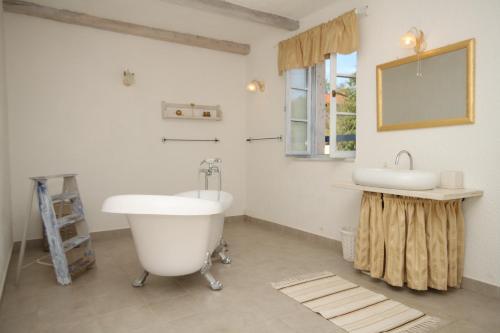 a bathroom with a tub and a sink and a mirror at Family friendly house with a swimming pool Skrapi, Central Istria - Sredisnja Istra - 7526 in Brajkovići