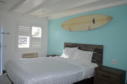 a bedroom with a bed with a surfboard on the wall at Calafia Inn San Clemente Newly renovated in San Clemente