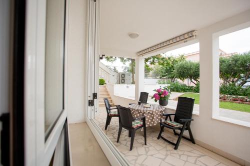 a patio with a table and chairs on a porch at Apartments by the sea Razanj, Rogoznica - 7484 in Ražanj