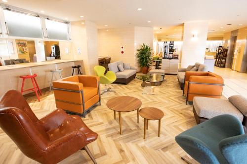 un vestíbulo con sofás, sillas y mesas en Court Hotel Mito, en Mito