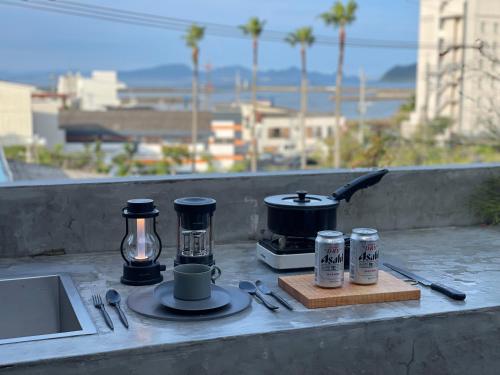 a table with a stove and a coffee maker and a coffee pot at hotel sou #sou in Goto