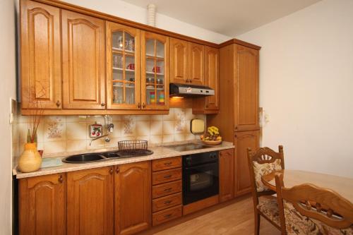 a kitchen with wooden cabinets and a sink and a stove at Apartments with WiFi Split - 7563 in Split