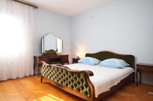 a bedroom with a bed with blue pillows and a mirror at Apartments by the sea Slatine, Ciovo - 7544 in Slatine